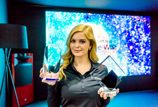 삼성전자 더 월이 'CEDIA 2018'에서 'AV/홈 씨어터' 부문 '2018 최고의 제품'에 선정됐고, AV 전문 매체 CE Pro에게 '최고의 유망 디스플레이 제품'으로 선정됐다. 삼성전자 모델이 각각의 트로피를 선보이고 있다. <삼성전자 제공>